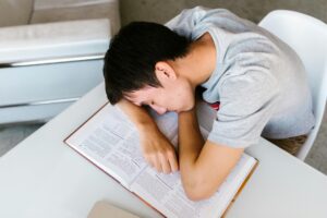 A student arranging small items on their desk to improve focus while learning how to make study habits that actually work, showing how tiny distractions in the study space affect concentration.
